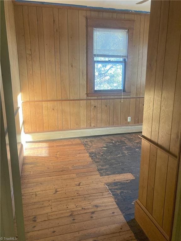 unfurnished room featuring dark wood-type flooring and wooden walls