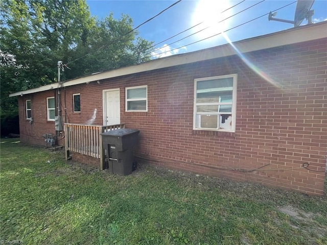 back of house featuring brick siding and a yard