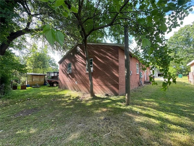 view of side of property with a lawn and brick siding