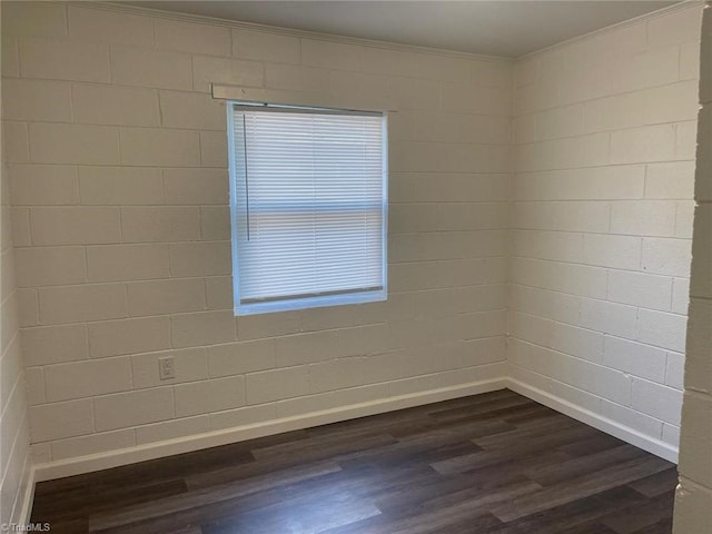 spare room with baseboards, ornamental molding, and dark wood-style flooring
