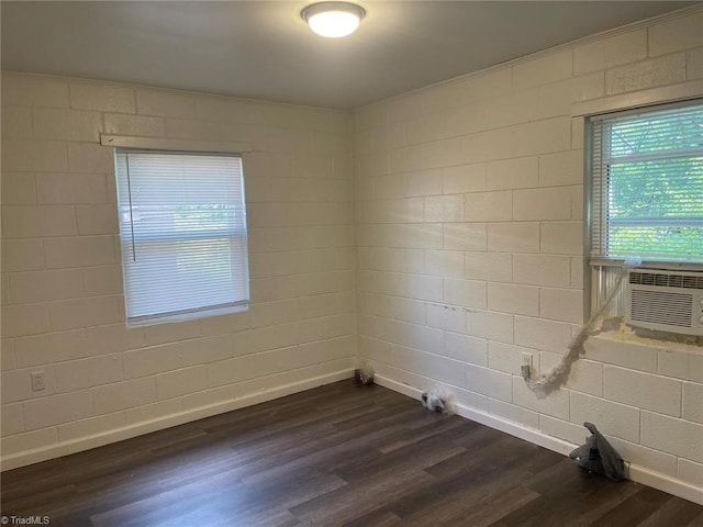 spare room with baseboards, dark wood-style floors, and cooling unit