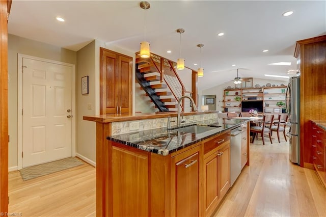 7 Pineburr Ct, Greensboro, NC 27455 - kitchen featuring a sink, stainless steel appliances, light wood-style floors, open floor plan, and dark stone counters
