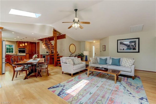 7 Pineburr Ct, Greensboro, NC 27455 - living area with stairway, light wood-style floors, a ceiling fan, lofted ceiling, and a skylight