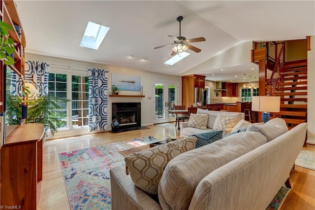 7 Pineburr Ct, Greensboro, NC 27455 - living area with a skylight, a fireplace with flush hearth, vaulted ceiling, a ceiling fan, and light wood-style floors