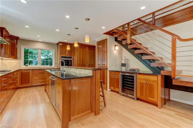7 Pineburr Ct, Greensboro, NC 27455 - kitchen featuring beverage cooler, appliances with stainless steel finishes, light wood finished floors, a sink, and backsplash