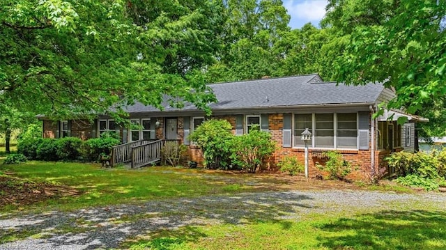 single story home featuring a front lawn and brick siding