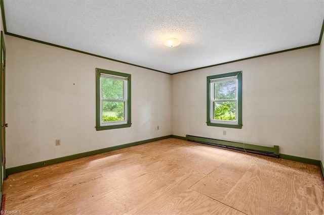 spare room featuring a baseboard radiator, plenty of natural light, ornamental molding, baseboards, and a textured ceiling