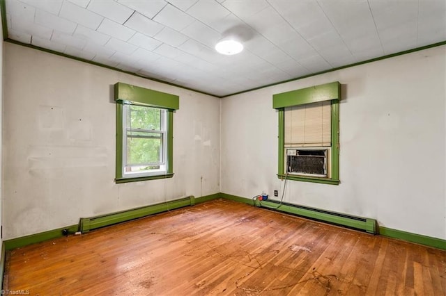 unfurnished room featuring a baseboard heating unit, hardwood / wood-style flooring, cooling unit, and baseboards