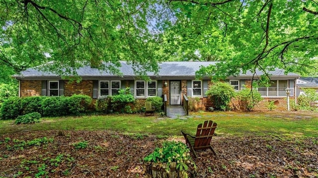 ranch-style house featuring a front yard and brick siding
