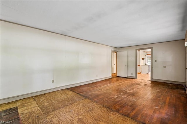 empty room with hardwood / wood-style flooring and baseboards