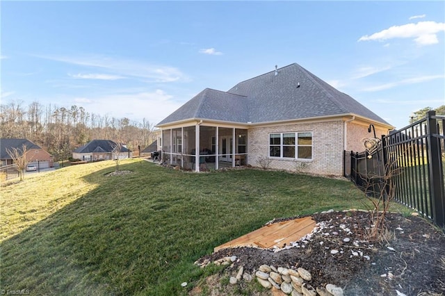 rear view of property with a yard and a sunroom