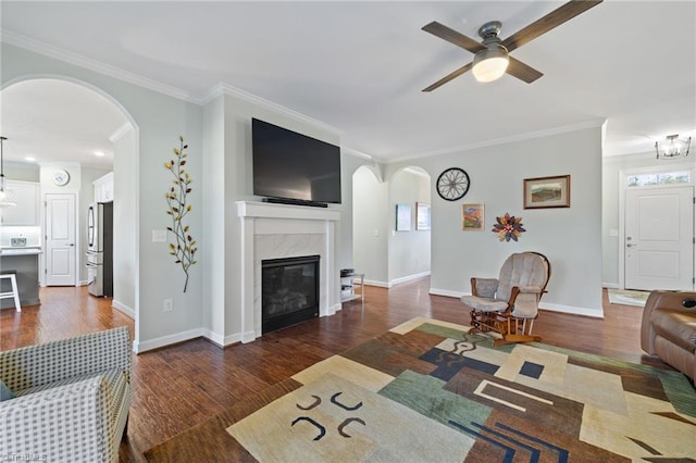 living room with crown molding, a high end fireplace, and dark hardwood / wood-style floors