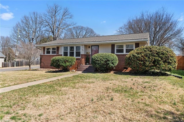 ranch-style home with brick siding, a front yard, and fence