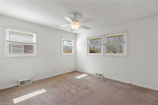 empty room featuring visible vents, a textured ceiling, and carpet