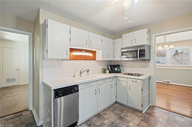 kitchen featuring stone finish floor, visible vents, appliances with stainless steel finishes, and a sink