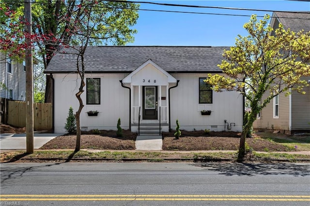 view of front of home with crawl space, fence, and roof with shingles