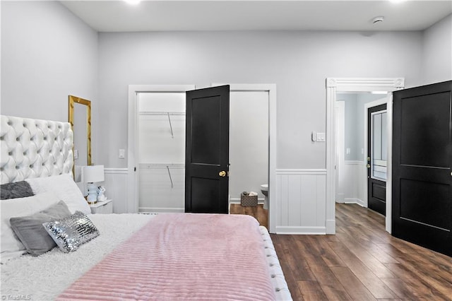 bedroom with a wainscoted wall, a closet, and dark wood-style flooring