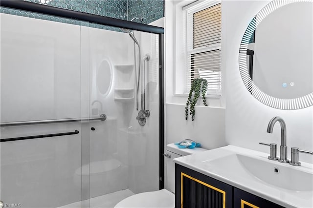 bathroom featuring vanity, a shower stall, and toilet