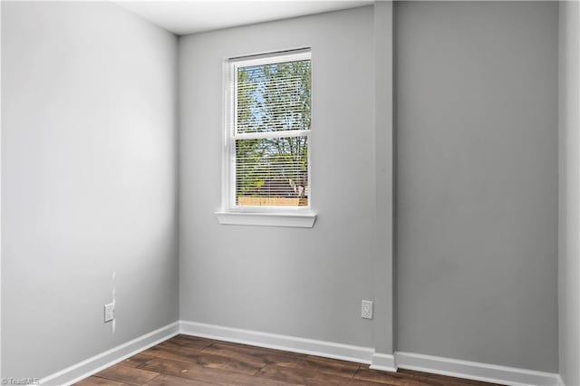 unfurnished room with dark wood-style flooring and baseboards