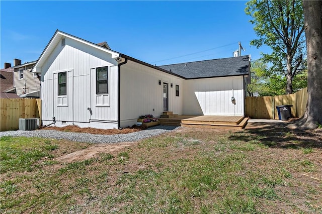 back of house featuring a fenced backyard, central AC unit, a yard, and a deck
