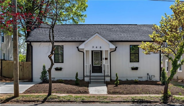 view of front of property with a shingled roof, fence, and crawl space