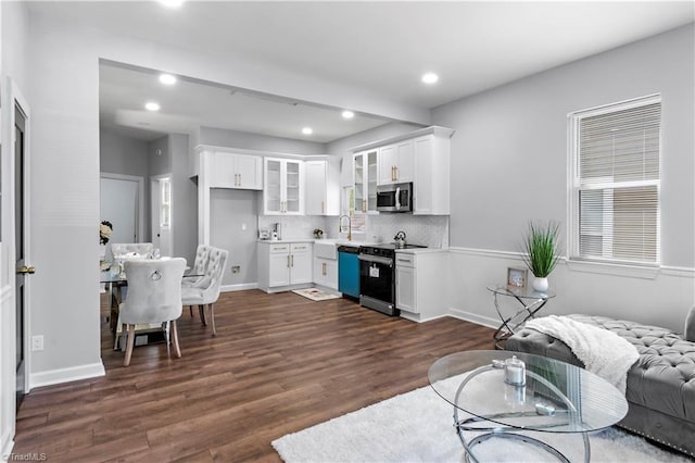 kitchen with a sink, stainless steel microwave, dishwashing machine, electric stove, and glass insert cabinets