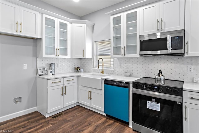 kitchen featuring electric range, dishwasher, a sink, white cabinets, and stainless steel microwave