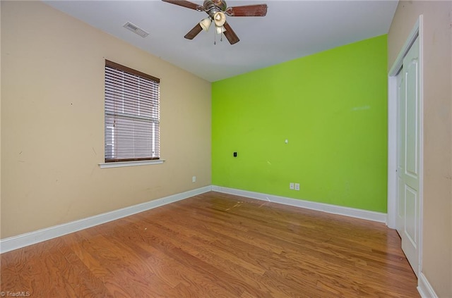 empty room with ceiling fan and light hardwood / wood-style flooring