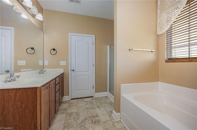 bathroom featuring shower with separate bathtub and vanity