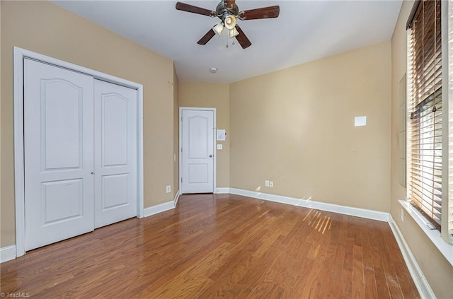 unfurnished bedroom with ceiling fan, a closet, and wood-type flooring