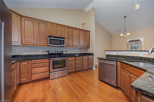 kitchen featuring decorative light fixtures, light hardwood / wood-style floors, sink, appliances with stainless steel finishes, and a chandelier