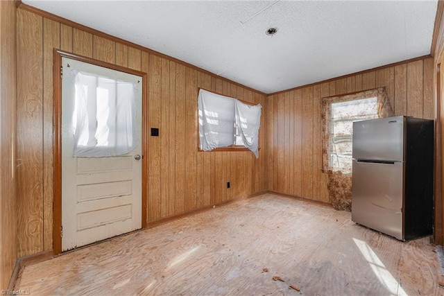 interior space with ornamental molding and wood walls