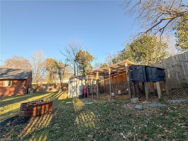 view of yard featuring a fire pit and a storage unit