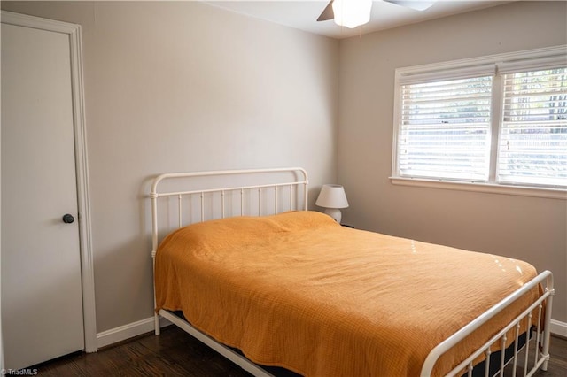 bedroom with dark hardwood / wood-style flooring and ceiling fan