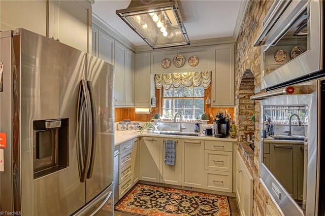 kitchen featuring sink, cream cabinets, crown molding, and stainless steel refrigerator with ice dispenser