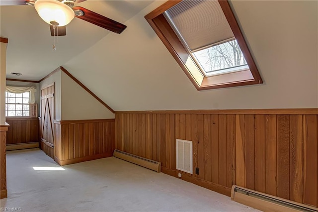 bonus room with a baseboard radiator and light carpet