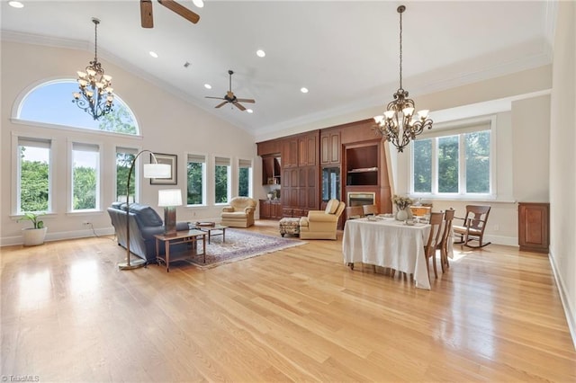 living room featuring crown molding, high vaulted ceiling, light hardwood / wood-style floors, and ceiling fan with notable chandelier