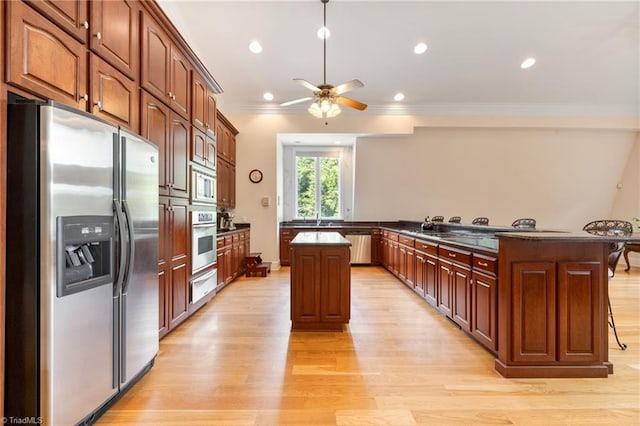 kitchen with ceiling fan, a center island, stainless steel appliances, kitchen peninsula, and crown molding