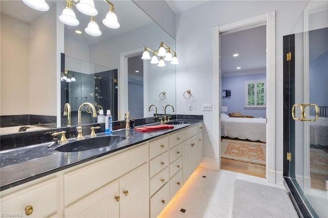 bathroom featuring tile patterned flooring, vanity, an inviting chandelier, and a shower with door