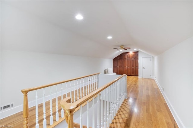 hall with light wood-type flooring and vaulted ceiling