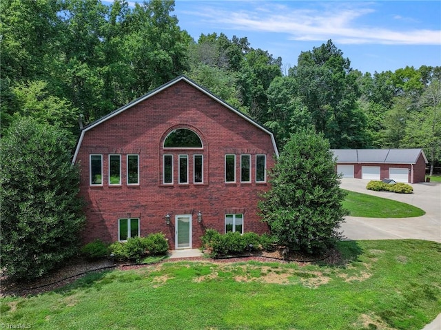 view of front of property with a garage, an outdoor structure, and a front yard