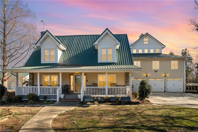 farmhouse-style home with covered porch and a garage