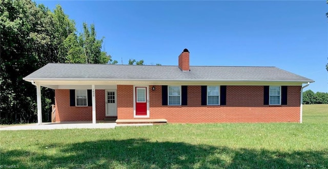 single story home featuring a chimney, a front lawn, and brick siding
