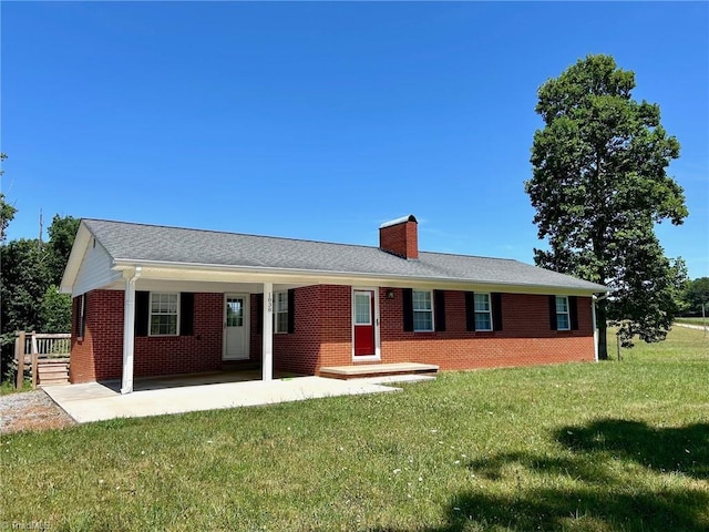 single story home featuring a chimney, a front lawn, and brick siding