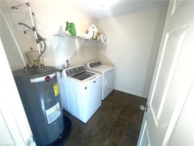 clothes washing area featuring separate washer and dryer, laundry area, and electric water heater