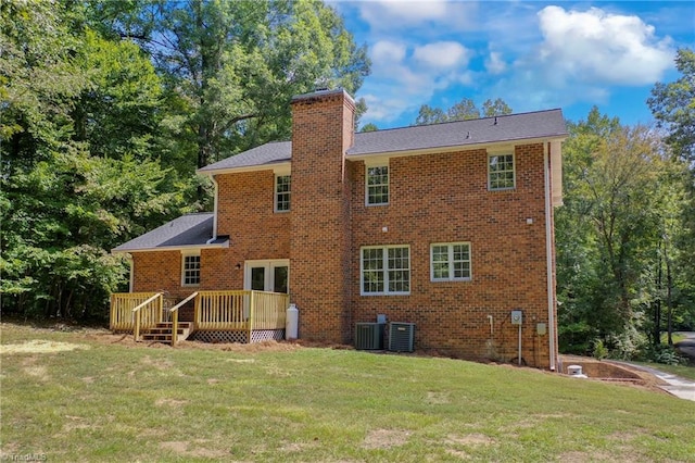 rear view of property featuring a wooden deck, a lawn, and cooling unit