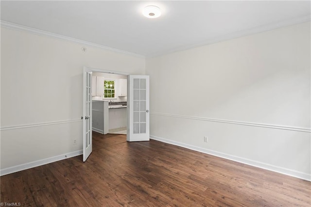 spare room with ornamental molding, dark wood-type flooring, and french doors