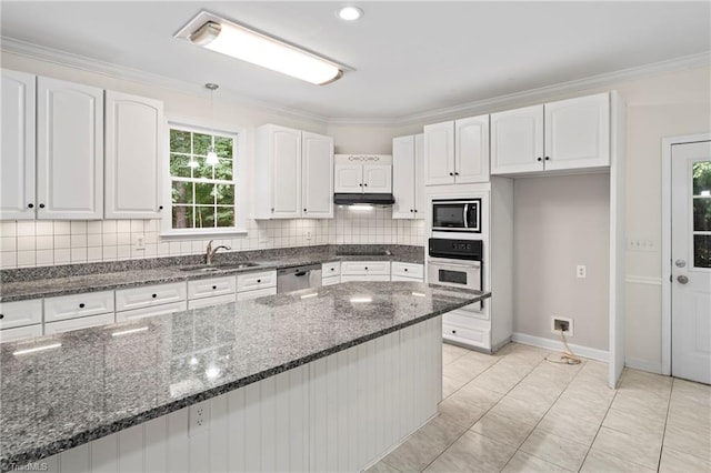 kitchen with dark stone countertops, appliances with stainless steel finishes, sink, and white cabinets