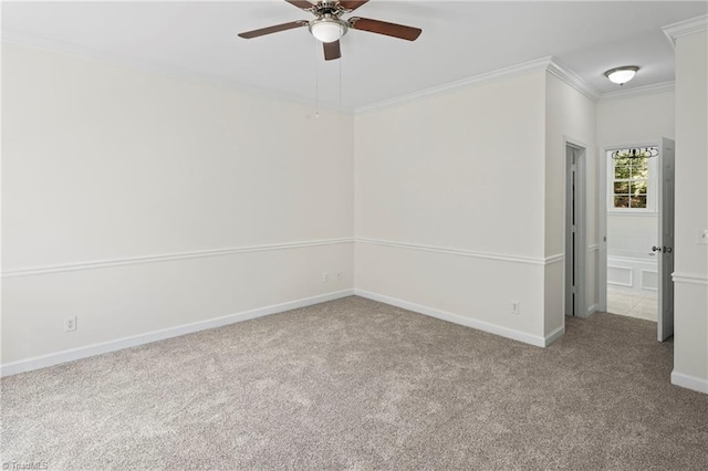 carpeted spare room featuring ceiling fan and ornamental molding