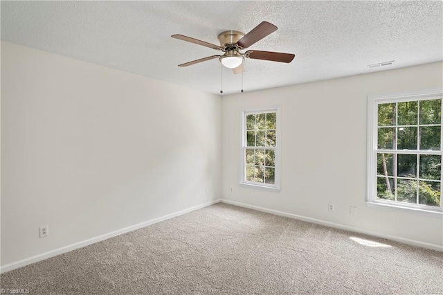 carpeted empty room featuring ceiling fan and a textured ceiling